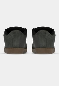 Μαύρα σουέτ αθλητικά παπούτσια με υφασμάτινη υφή, διαθέτουν καφέ λάστιχο σόλα, επενδυμένο κολάρο και λογότυπο της μάρκας στη φτέρνα.