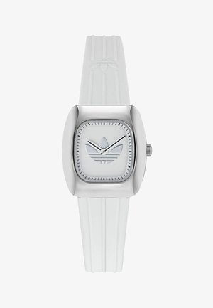 Bijeli gumeni sat s kvadratnim srebrnim kućištem. Ima bijeli brojčanik s logotipom u tri pruge i minimalističkim srebrnim kazaljkama. Teksturirani remen.