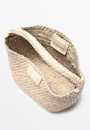Rektangulær beige flettet kurv med flettet kant og læderlapper, mærket "Massimo Dutti", vist i en let vinkel.