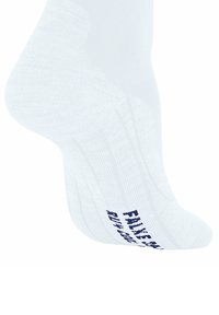 Calzino bianco inclinato per mostrare il testo sul fondo che recita "FAKE" in blu scuro, evidenziando un elemento di design giocoso o umoristico.