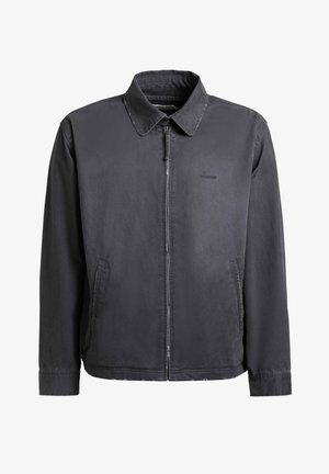 Donkergrijze herenjas met rits en kraag, twee zijzakken en een subtiel merklogo op de linkerborst.