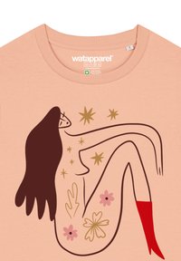 Helles rosa T-Shirt mit einer stilisierten Illustration einer Frau mit langen Haaren, umgeben von Sternen und Blumen in roten und goldenen Akzenten.