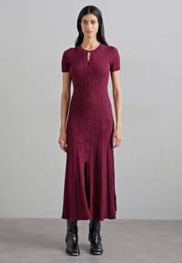 Burgundijas krāsas adīta midi kleita ar īsām piedurknēm, pogu aizdare priekšpusē un priekšējā plaisa. Gluda tekstūra un ribota apdare.