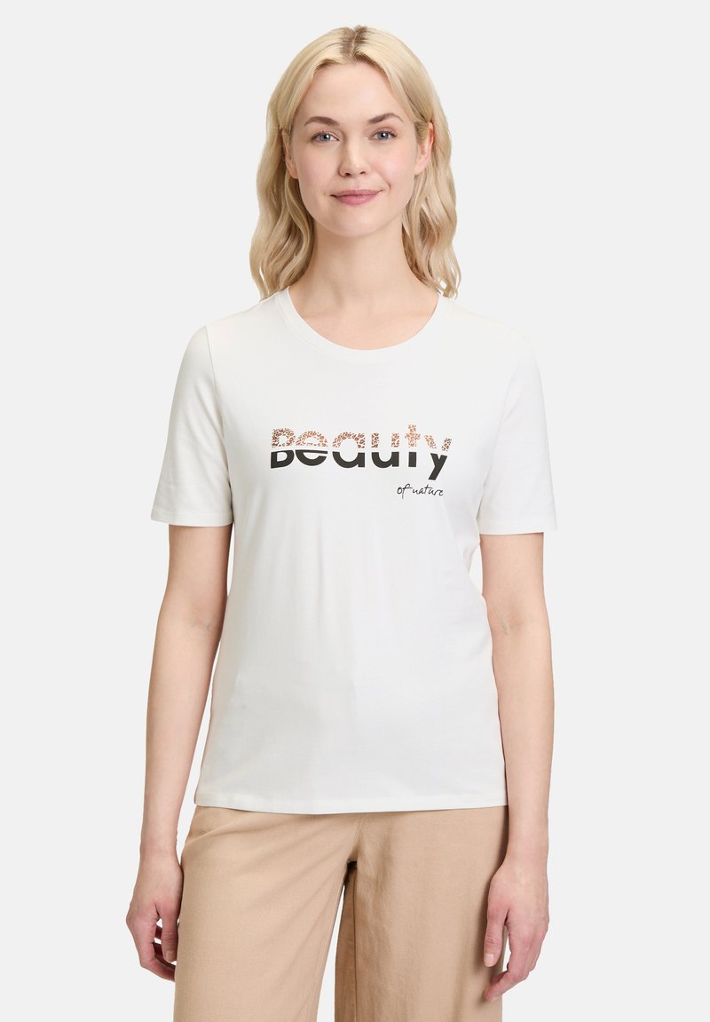 Hvid kortærmet bomuldstrøje med "Beauty" i sort og mønstret skrift, med "of nature" i en flydende skrift nedenfor.