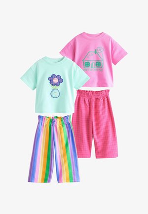 Dva topa kratkih rukava, jedan svijetloplavi s grafikom cvijeta i vaze, drugi ružičasti s kućom i tekstom "Dom je moje sretno mjesto", upareni s šarenim kratkim hlačama.