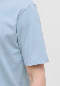 Svijetloplavi kratki rukav T-shirt izrađen od mekog pamuka. Ima okrugli izrez i uredno šivenje na rukavima i rubu.