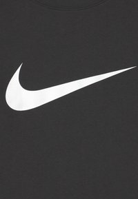 T-shirt in cotone nero con un grande logo Swoosh bianco di Nike centrato sul petto. Tessuto morbido e design classico con scollo rotondo.