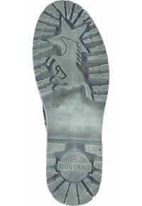 Suela de una bota con un gráfico de unicornio en relieve, una banda de rodadura texturizada con patrones circulares y lineales, y bordes estriados. Tamaño 37, de la marca "Mustang."