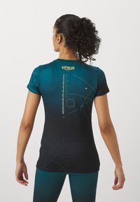 Mustmust ja teal värvi sportlik särk, millel on lühikesed varrukad, graafiline disain seljal ja "VENUM" logo kaelus. 