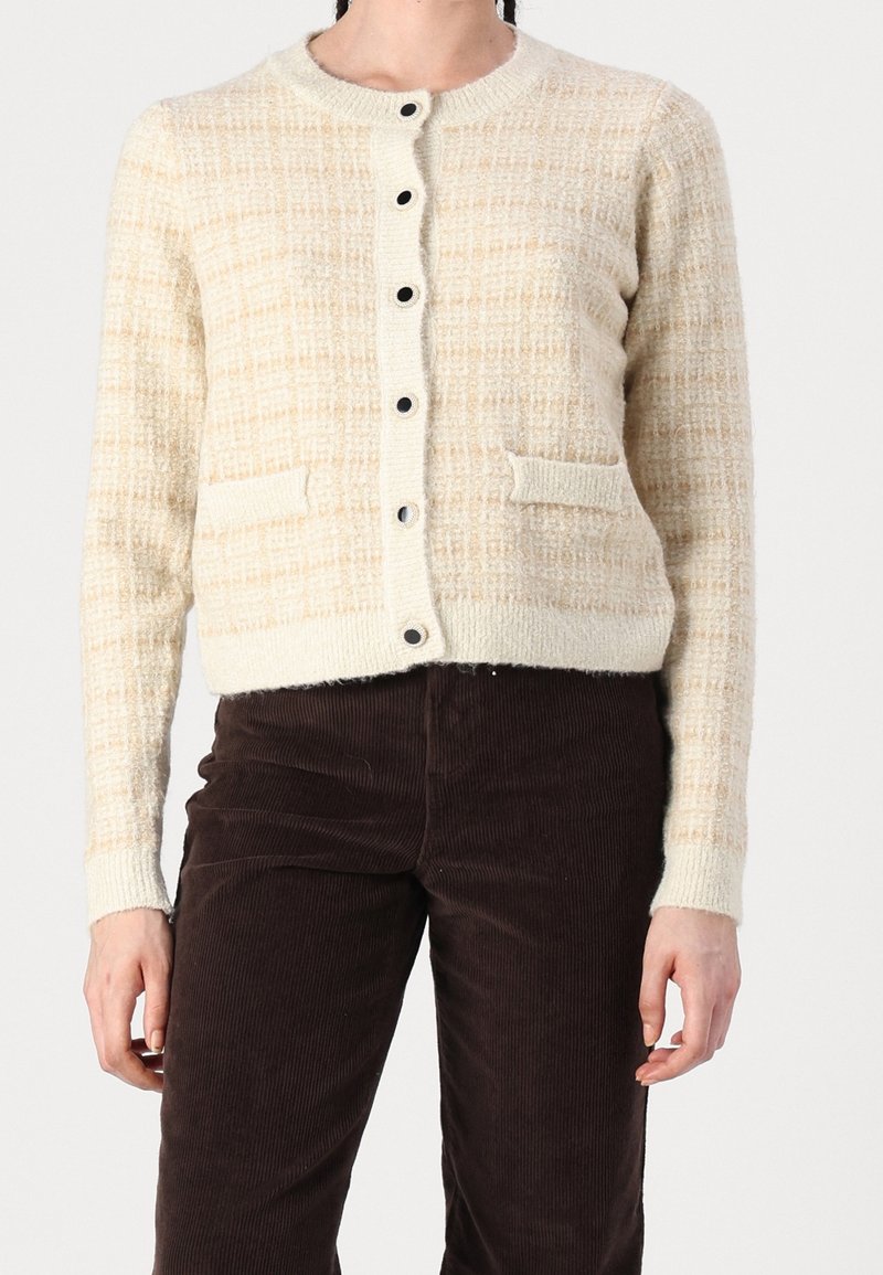 Vlněný krémový cardigan s texturovaným vzorem, kulatým výstřihem a černými knoflíky; má dvě přední kapsy a žebrované manžety.