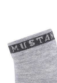 Grå sok med en blød tekstur, der har en mørkegrå kant øverst. Kanten viser ordet "MUSTANG" i lysegrå skrift.