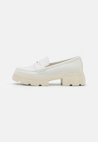 White loafers with a chunky beige sole, featuring a smooth leather upper, a front strap detail, and stitched accents on the sides.
