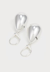 Silver droppformade örhängen med en glänsande yta och ett säkert lås, uppvisade mot en vit bakgrund.
