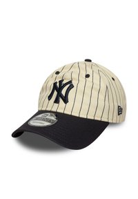 Beige baseball cap med marineblå striper. Har en brodert marineblå NY-logo, svart skygge og justerbar bakside. Teksturert stoff.