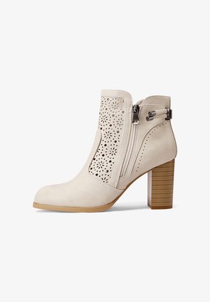 Stivale alla caviglia beige con design floreale perforato, zip laterale e tacco in legno impilato. Materiale in pelle liscia con punta arrotondata.