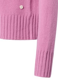 Roze wollen cardigan met ribbelstructuur aan de zoom en manchetten, aangevuld met een enkele ronde knoopdetail aan de voorkant.