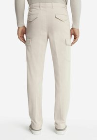 Beige cargobroek met dubbele achterzakken en zijflapzakken. Gemaakt van zachte stof, met een recht model en een subtiele textuur.