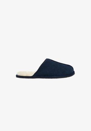 Zapatilla de ante en color azul marino con un forro interior suave, diseño de espalda abierta, punta redonda y suela de goma texturizada. Estilo simple y funcional.