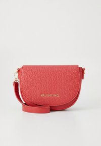 Červená kabelka Red Valentino přes rameno s reliéfním vzorem loga, zakřiveným klopou, kováním ve zlaté barvě a nastavitelným popruhem na jednobarevném pozadí.