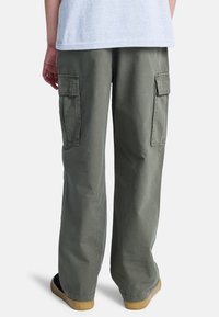 Olivgrüne Cargo-Hosen mit lockerem Schnitt, ausgestattet mit seitlichen Taschen, einem strukturierten Stoff und geradem Bein-Design mit elastischen Bündchen.
