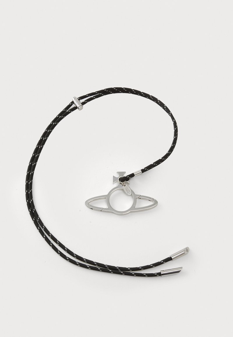 Bolo-slips med en sirkulær sølvmetalldekorasjon med langstrakte sider, festet til svarte flettede snorer med hvite detaljer og metalltips.