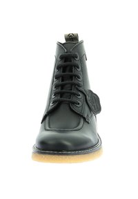 Bota de cuero negro con cordones en la parte delantera, cuello acolchado y suela de goma. Presenta una etiqueta en el lateral y costuras en contraste a lo largo de la suela.