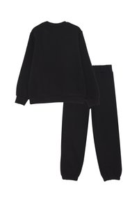 Set di felpa e pantaloni della tuta neri. Tessuto liscio, polsini e vita a coste, vestibilità comoda, nessun motivo o logo visibile.