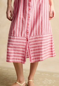 Rosa und weiß gestreiftes Kleid mit Knopfleiste, das eine glatte Textur, einen knielangen Saum und einen Schlitz vorne am Saum aufweist.