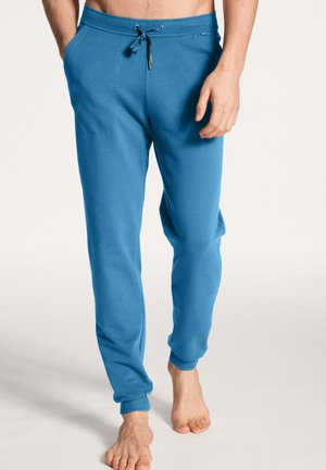 Blauwe katoenen joggers met elastische tailleband en verstelbaar trekkoord, voorzien van twee zijzakken en geribbelde boorden bij de enkels.