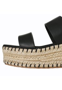 Sandalo platform in pelle nera con suola in juta intrecciata, caratterizzato da un bordo spesso e testurizzato cucito in nero. Design con punta aperta e cinghia alla caviglia.