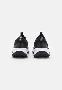 Zapatillas deportivas negras con parte superior de malla, talón texturizado y media suela blanca. Presentan dos lengüetas y una suela de goma negra con patrón.