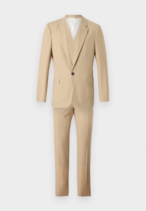 Beez värvi ülikond, mis on valmistatud kangast, sisaldab ühte nööpidega sätitud bleiserit, millel on lõikekaelus ja sinna sobivad kohandatud püksid. Omab ühte nööpi ja kahte taskut.