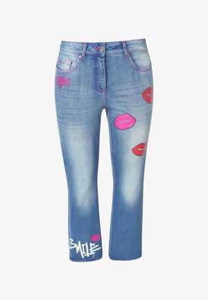 Denim jeans med en lys blå vask, der har pink og røde læbetryk og ordet "SMILE" i hvidt, med livlige pink syninger som accent.