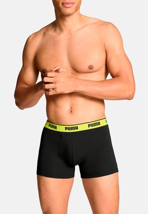 Schwarze Boxershorts aus Baumwolle mit einem gelben elastischen Taillenbund mit Markenlogo; enganliegendes Design und glatte Textur.