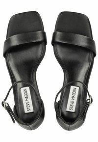 Sandali in pelle nera con punta quadrata, fascia ampia sulla parte superiore del piede e cinturino alla caviglia con fibbia in argento; texture liscia.