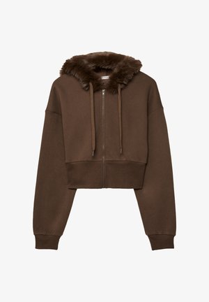 Rjava skrajšana zip-up kapuca z umetnim krznom obloženim kapuco, z vrvicami in rebrovanimi manšetami. Mehka tekstura z sproščenim krojem.