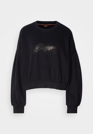 Svart cropped sweatshirt med ribbestrikket halslinning, puffede ermer, og en dekorativ glitrende grafikk på forsiden. Myk stoff med elastisk kant.
