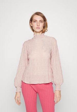 Ροζ μπλούζα μακρυμάνικη με υφή, πτυχώσεις και φουσκωτό ψηλό γιακά. Συνδυάζεται με ριγέ ροζ παντελόνι.