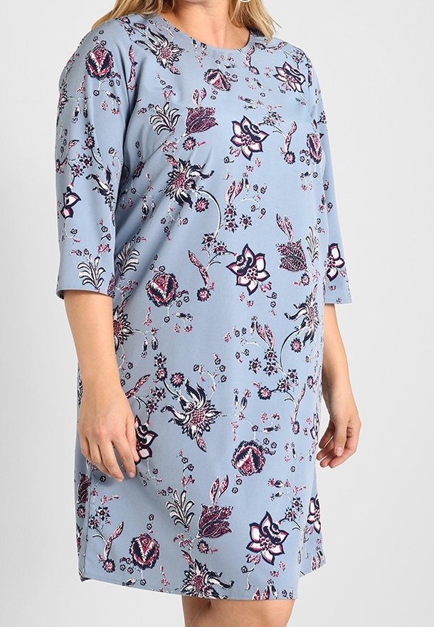 Vestido azul claro con estampados florales en rosa y azul oscuro. Presenta mangas cortas y un escote redondo. Tejido suave, diseño hasta la rodilla.