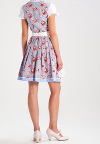 Robe à carreaux bleus et blancs avec motif floral, manches courtes bouffantes, ceinture blanche, bordure en dentelle à l'ourlet, associée à des talons blancs.