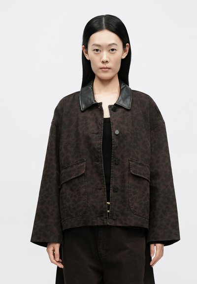 Jachetă maro cu imprimeu leopard și guler din piele neagră. Are închidere frontală cu nasturi și două buzunare mari. Croială lejeră.