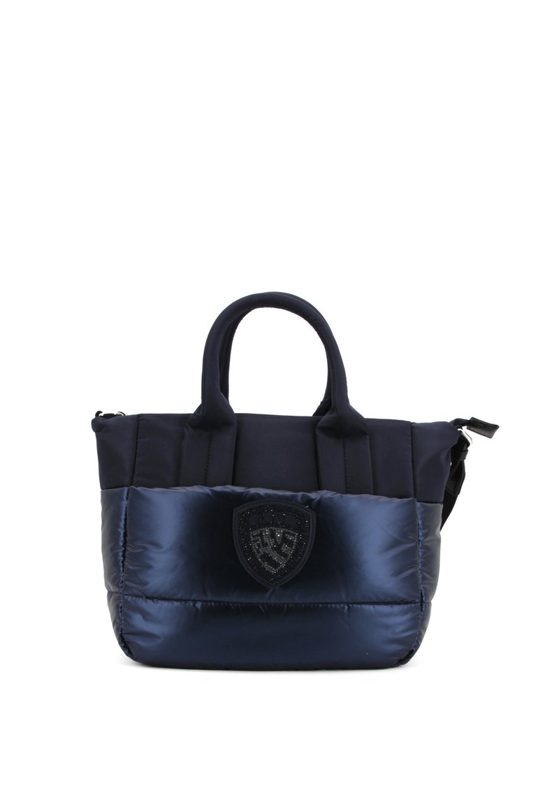 Bolso tote acolchado de color azul marino con doble asa superior, cierre de cremallera y un parche logo en el frente. El material es suave y brillante, con un diseño acolchado.