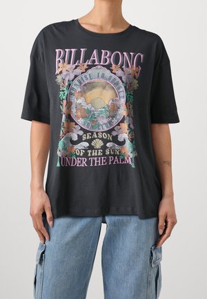 Black oversized t-shirt featuring a colorful graphic design with floral elements and text, made from soft cotton material.