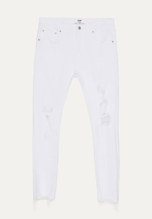 Weiße Slim-Fit-Denim-Jeans mit abgenutzten Details an den Oberschenkeln und ausgefransten Säumen, ausgestattet mit vorderen und hinteren Taschen mit Knopfverschluss.