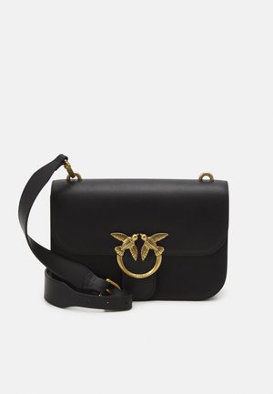 Zwarte leren crossbodytas met klep, brede verstelbare riem en clasp met goudkleurige ring waarop twee vogels elkaar aankijken.