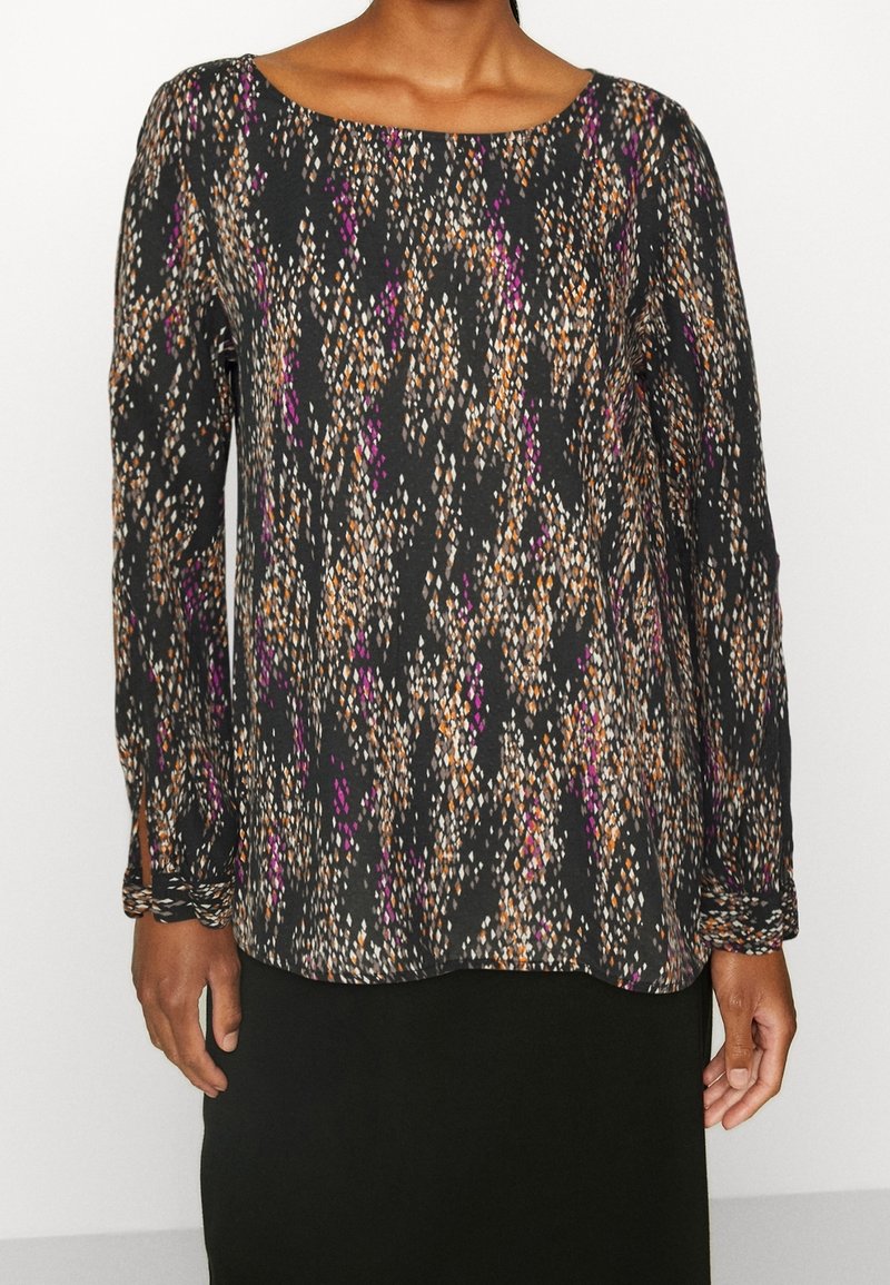 Top a maniche lunghe di colore nero con un motivo astratto colorato che presenta accenti arancioni, bianchi e viola; scollo a barchetta e tessuto morbido.