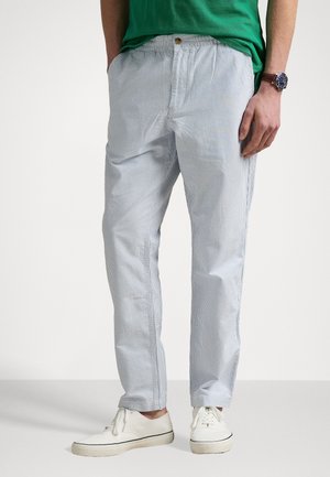 Lichtblauwe en witte gestreepte broek met een elastische tailleband, met zijzakken en een losse pasvorm, gedragen met witte schoenen.