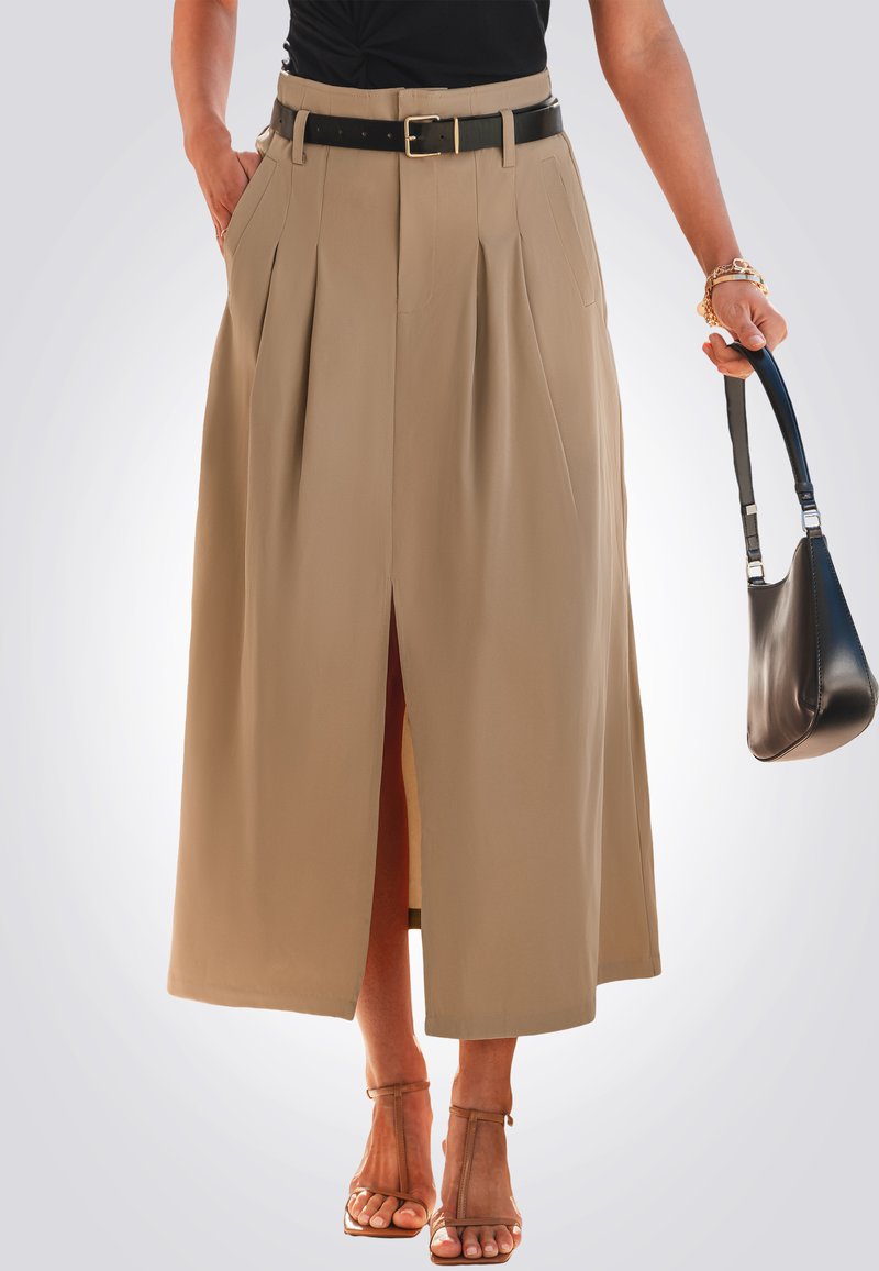 Falda beige de longitud media con pliegues, abertura delantera y un cinturón negro. Combinada con una blusa negra y complementada con un bolso negro pequeño.