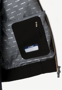 Tasca interna nera con chiusura a zip, fodera grigia con motivo a logo ripetuto e un'etichetta per nome ed email.
