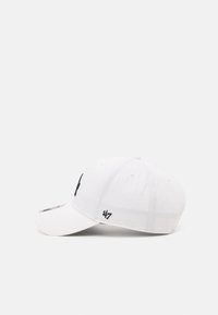 Gorra de béisbol blanca con visera curvada, logo negro en la parte frontal y detalles cosidos. La tela parece suave con un diseño estructurado.
